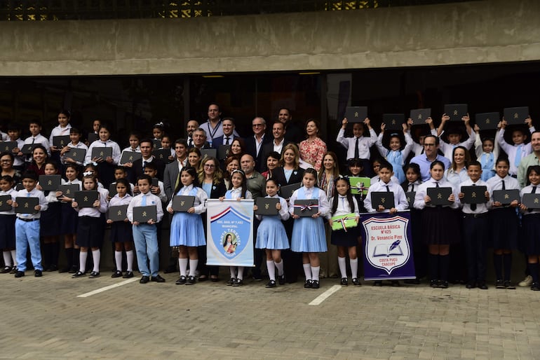 Niños posan junto a empresarios, autoridades nacionales de la CEAL con las nuevas notebooks entregadas, para el Proyecto de Integración Tecnológica para la Mejora de la Calidad Educativa.