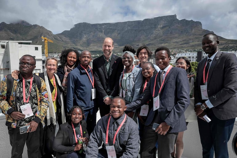 El príncipe William de Gran Bretaña, posando con un grupo de jóvenes, con Table Mountain al fondo, en el Programa Juvenil de Líderes Climáticos del Premio Earthshot. (GIANLUIGI GUERCIA / POOL / AFP)