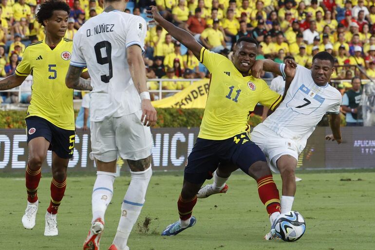 Jhon Arias (c) de Colombia disputa el balón con Nicolás de la Cruz (d) de Uruguay hoy, en un partido de las Eliminatorias Sudamericanas para la Copa Mundial de Fútbol 2026 entre Colombia y Uruguay en el estadio Metropolitano en Barranquilla (Colombia).