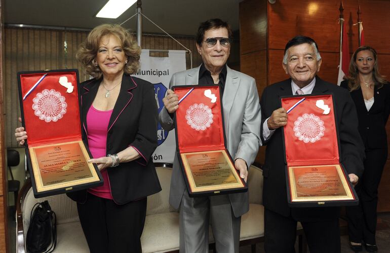 Alma María Vaesken, Johnny Torales y Casto Darío Martínez, integrantes de Los Tres Sudamericanos, recibiendo la declaración de Hijos ilustres de la Municipalidad de Asunción en 2012.