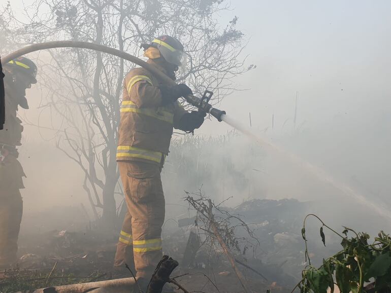 Bomberos intentan sofocar un foco de incendio en la bahía de Asunción, ayer sábado.