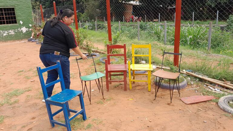 La tesorera de la Aces, Blanca Gamarra, ordena algunas de las sillas que se encuentran en pésimo estado y que utilizan los alumnos.