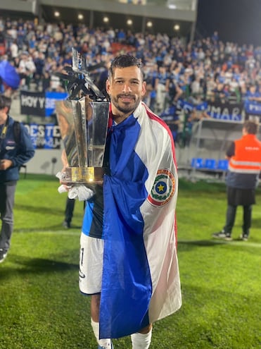 Miguel Samudio celebra con el trofeo de campeón y con la bandera paraguaya