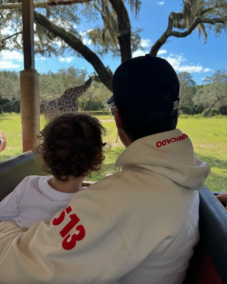 Marc Anthony y Marquito observando una jirafa durante el safari familiar por Animal Kingdom. (Instagram/Nadia Ferreira)