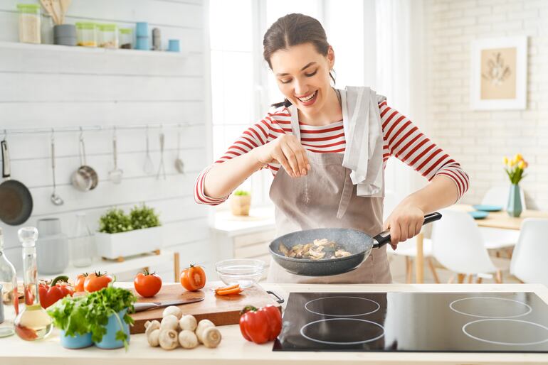 Mujer feliz cocinando.