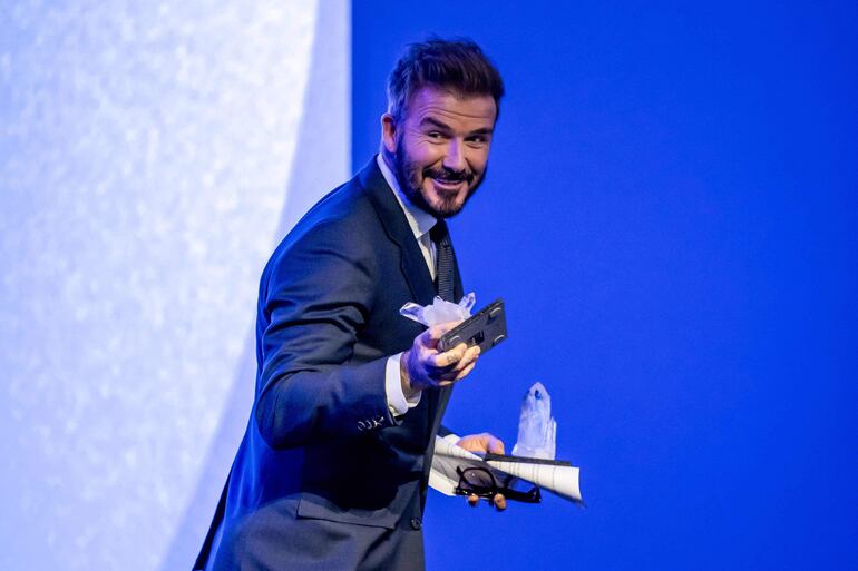 El exfutbolista inglés y Embajador de Buena Voluntad de UNICEF, David Beckham, feliz después de recibir su premio durante la ceremonia de los Premios Crystal en la reunión anual del Foro Económico Mundial (WEF).
 (Fabrice COFFRINI / AFP)