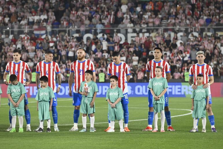 Los jugadores de la selección de Paraguay en la formación protocolar previa al partido contra Brasil por la octava fecha de las Eliminatorias Sudamericanas 2026 en el estadio Defensores del Chaco, en Asunción.