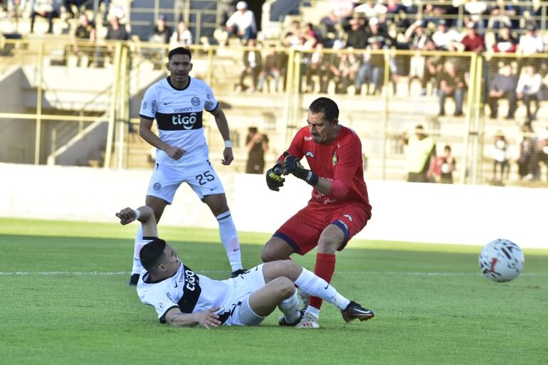 Hugo Fernández (Olimpia) disputa el balón con Víctor Samudio (Trinidense), en el estadio Villa Alegre.