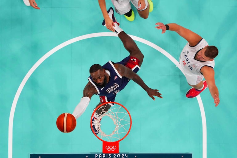 LeBron Raymone James (39) encesta tras la mirada de Jokic.