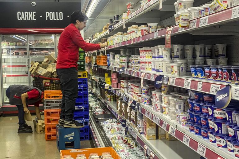 Empleados de un supermercado organizan productos en los estantes, en Buenos Aires (Argentina). EFE/ Juan Ignacio Roncoroni