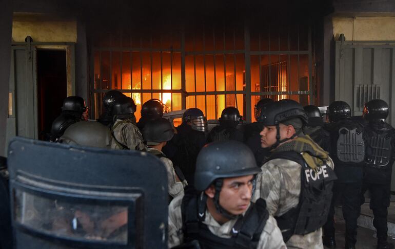 Miembros de las fuerzas de seguridad observan desde fuera de la cárcel el fuego. 