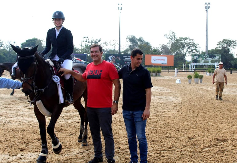 Luciana Llano, junto a su padre e instructor, posa luego de ganar la competencia en 1,30 metro.