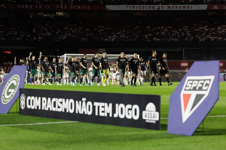 Jugadores de Sao Paulo y de Goiás portan camisetas que llevan el mensaje "Con racismo no hay juego", previo al inicio de un partido por la Serie A brasileña en el estadio Morumbí en Sao Paulo (Brasil). Una campaña contra el racismo en el fútbol y de solidaridad con Vinícius Júnior, víctima de insultos racistas en España, unió este fin de semana a todos los competidores del Campeonato Brasileño en los diez partidos por la octava jornada de la Liga.