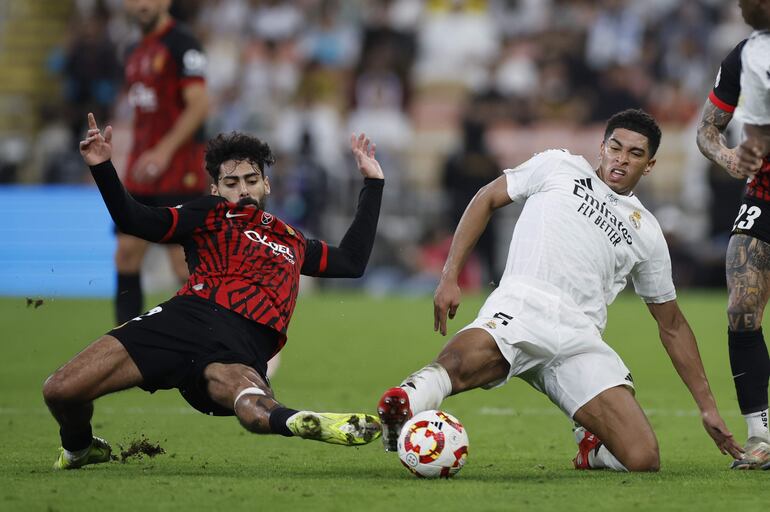 YEDA (ARABIA SAUDÍ), 09/01/2025.- El centrocampista inglés del Real Madrid Jude Bellingham (d) lucha con Samu Costa, del Mallorca, durante el partido de semifinales de la Supercopa de España de fútbol entre el Real Madrid y el RCD Mallorca, este jueves en Yeda. EFE/ Alberto Estévez
