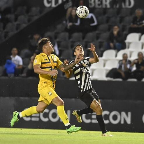 Juan Vera, jugador de Trinidense, peleando el balón con Lorenzo Melgarejo, de Libertad.