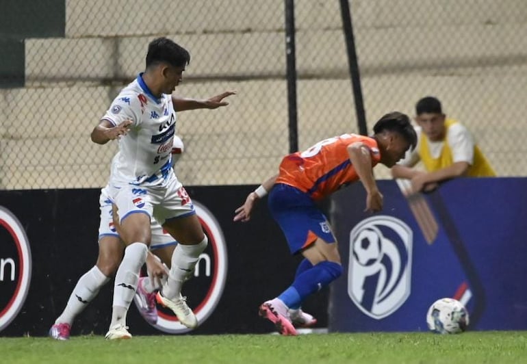 Javier Domínguez cuida la pelota ante la marca de Leandro Meza