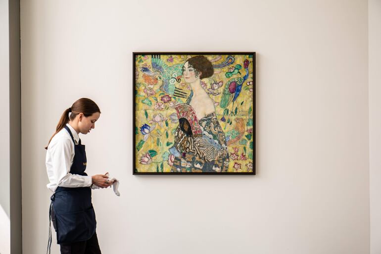 Una mujer junto al retrato del pintor austríaco Gustav Klimt, "Dama con Abanico", que  se pondrá a subasta el 27 de junio por la casa de pujas Sotheby's en Londres y que ha anunciado este martes que espera alcanzar por la obra la cifra de 65 millones de libras, es decir, 80 millones de euros. 