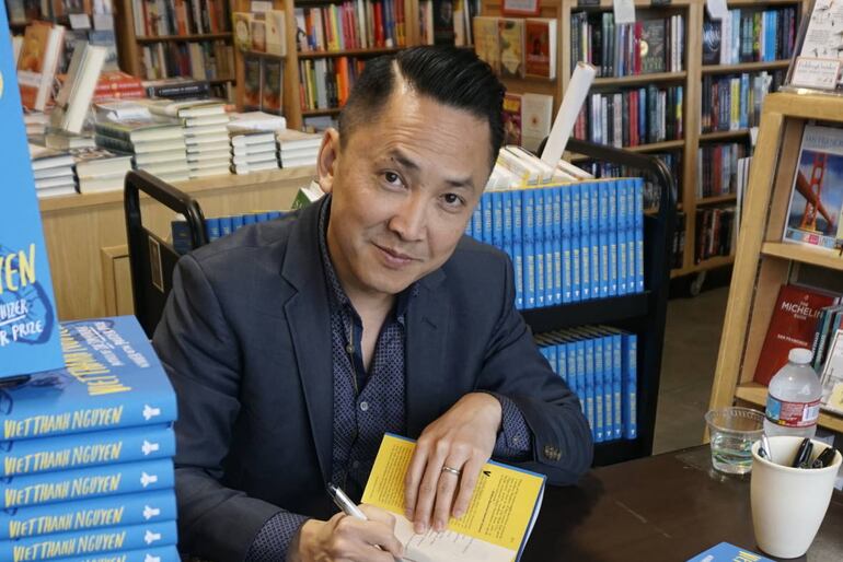 El novelista y Premio Pulitzer de Ficción Viet Thanh Nguyen firmando ejemplares de su libro "The Refugees" (Foto: Sasha Khokha)