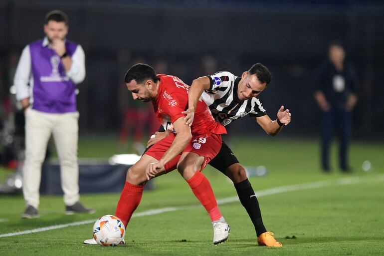 Abel Paredes (i), futbolista de Sportivo Ameliano, y Marcelo Fernández, jugador de Libertad, pelean por el balón en un partido de los octavos de final de la Copa Sudamericana 2024 en el estadio Defensores del Chaco, en Asunción.