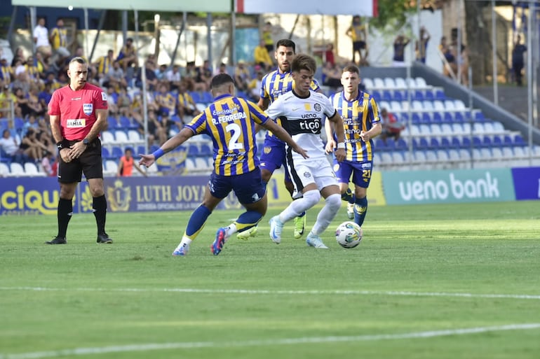 Javier Domínguez (d), jugador de Olimpia, domina el balón en el partido frente a Sportivo Luqueño por la cuarta fecha del torneo Apertura 2025 del fútbol paraguayo en el estadio Luis Salinas, en Itauguá.