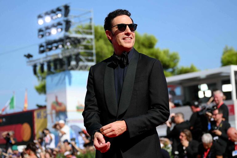 El actor Sacha Baron Cohen eligió una sobria y elegante tenida oscura para posar en la red carpet del Festival de Cine de Veneica. (Marco BERTORELLO / AFP)