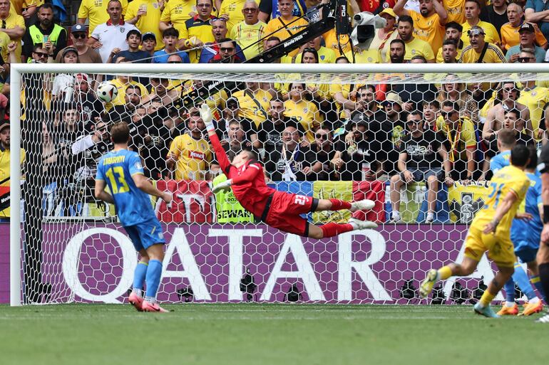 Munich (Germany), 17/06/2024.- Nicolae Stanciu of Romania (R) scores the 1-0 goal against goalkeeper Andriy Lunin (C) of Ukraine during the UEFA EURO 2024 Group E soccer match between Romania and Ukraine, in Munich, Germany, 17 June 2024. (Alemania, Rumanía, Ucrania) EFE/EPA/MOHAMED MESSARA
