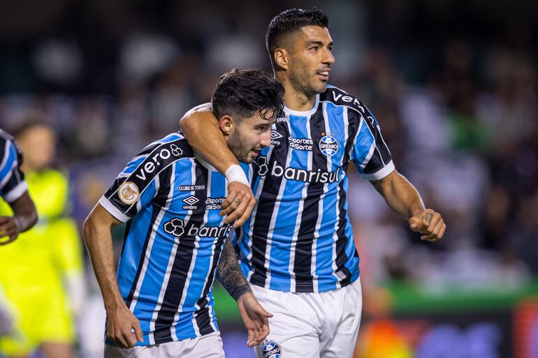 El paraguayo Mathías Villasanti, futbolista de Gremio de Porto Alegre, festeja un gol con el uruguayo Luis Suárez en el partido ante Coritiba por la jornada 31 de la Serie a de Brasil en el estadio Couto Pereira, en Curitiba.