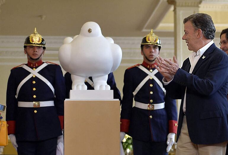 El expresidente de Colombia, Juan Manuel Santos, junto a la escultura "La paloma de la paz" realizada por Botero.