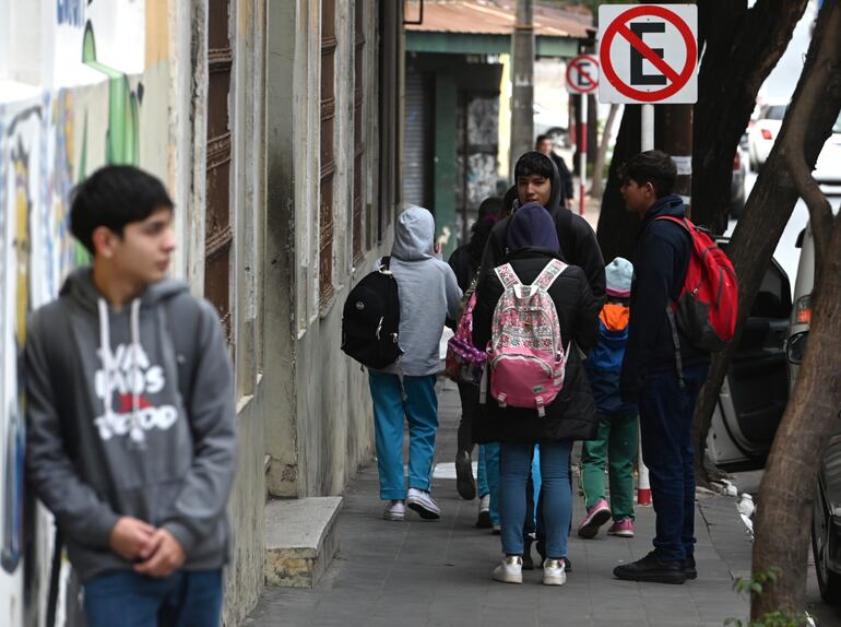 Protegidos del viento helado los estudiantes se dirigen a sus colegios.