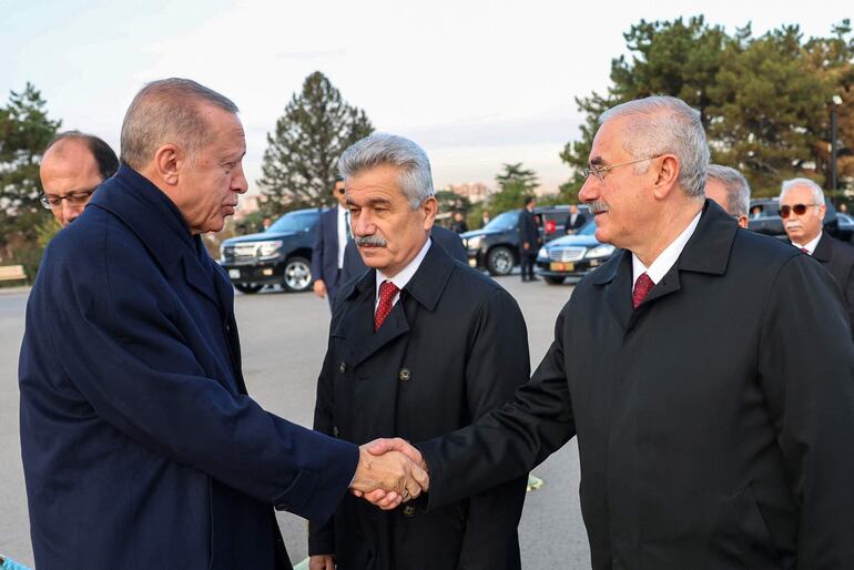 El presidente turco Recep Tayyip Erdogan (i) saluda al presidente de la Suprema Cortes de Apelaciones, Mehmet Akarca (d) en Ankara.  (AFP)