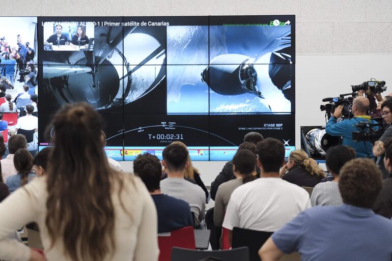 Un grupo de personas observa este viernes en La Laguna la retransmisión del lanzamiento al espacio del primer satélite canario, ALISIO-1, por la empresa estadounidense SpaceX desde la Base Vandenberg de la Fuerza Aérea Estadounidense de California (EEUU).