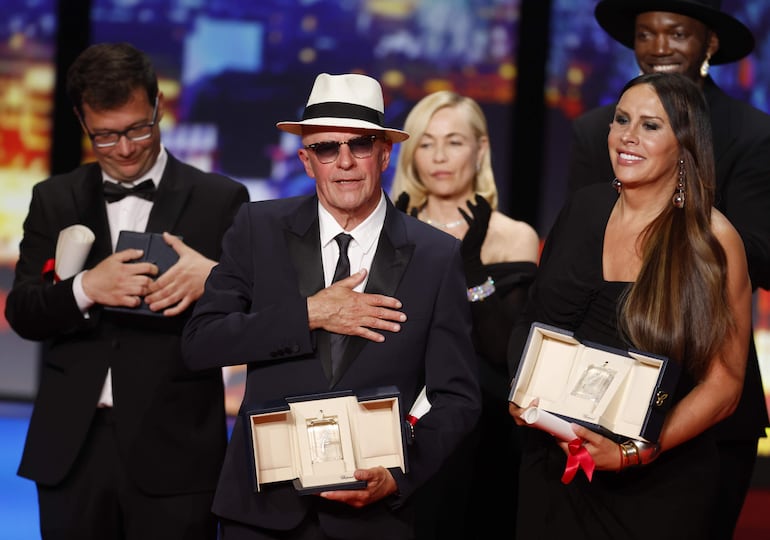 Jacques Audiard, director de "Emilia Pérez", se alza con el Premio del Jurado, escoltado por Karla Sofía Gascón, una de las actrices de su película que también fueron premiadas en conjunto por sus interpretaciones.