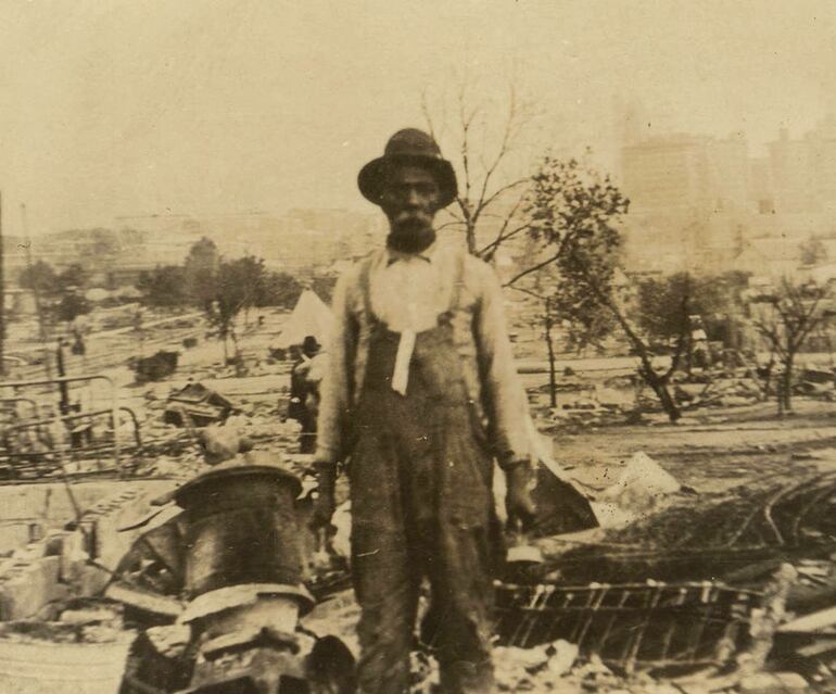 Un hombre entre las ruinas después de la Masacre de Tulsa de 1921.