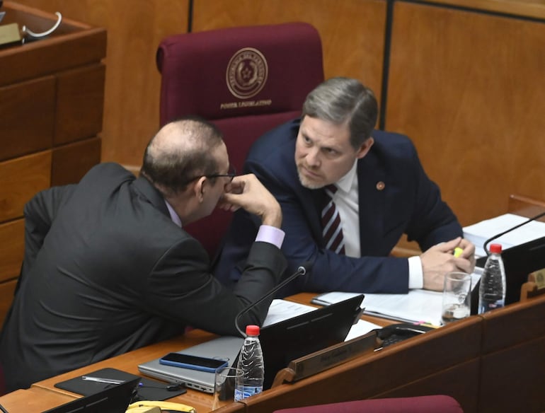 El senador cartista Erico Galeano (I), procesado por supuesto lavado de dinero y asociación criminal conversa con el líder de la bancada cartista, Natalicio Chase, conversan en la sala de sesiones del Senado.