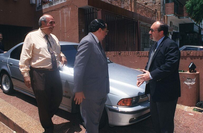 El abogado Julio Martinessi, Heraldo Arruda y el fiscal Alejandro Nissen junto al automóvil BMW regalado al entonces presidente Luis Angel González Daher que habría sido robado en Brasil. 