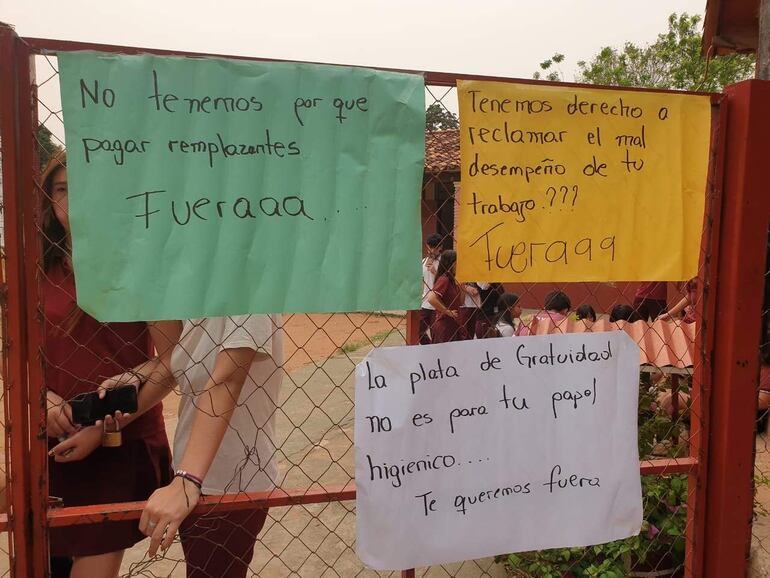 El portón principal llaveado y con carteles de repudio contra la directora de la institución.