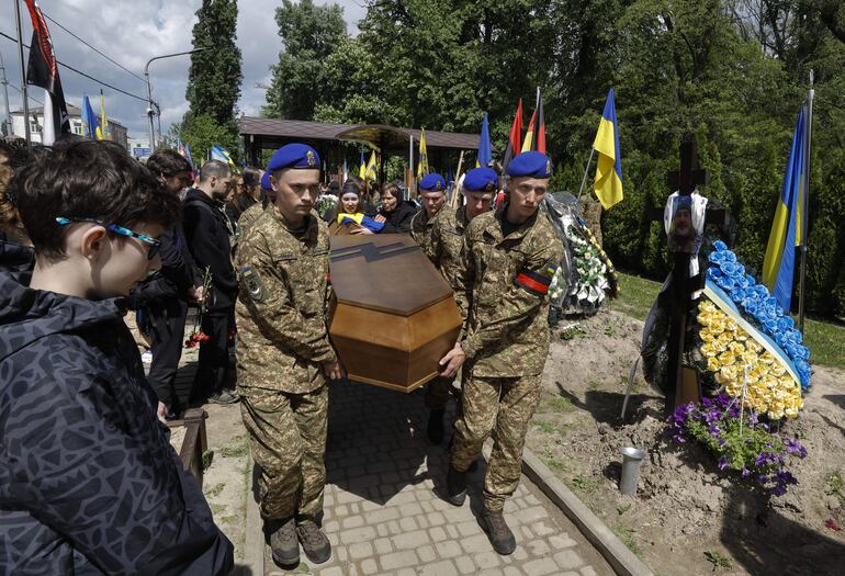 Miembros de las fuerzas de defensa ucranianas acompañan el féretro de un soldado muerto en combate en la guerra con Rusia.