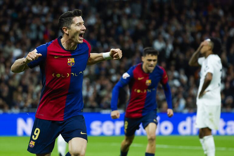 MADRID, 26/10/2024.- El delantero polaco del FC Barcelona Robert Lewandowski (i) celebra tras anotar un gol, durante el partido de la jornada 11 de LaLiga EA Sports entre el Real Madrid y el FC Barcelona, este sábado en el estadio Santiago Bernabéu, en Madrid. EFE/Juanjo Martín
