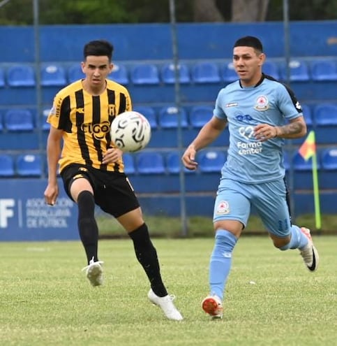 Romeo Benítez, jugador de Guaraní, disputa el balón con Héctor Lezcano, de Resistencia.