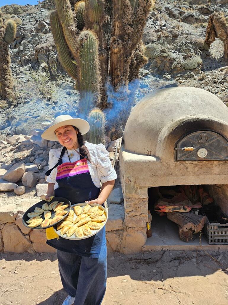 Anita Ponce saca del horno a leña de la bodega Amanecer Andino, en Chañarcito, sus deliciosas empanadas.