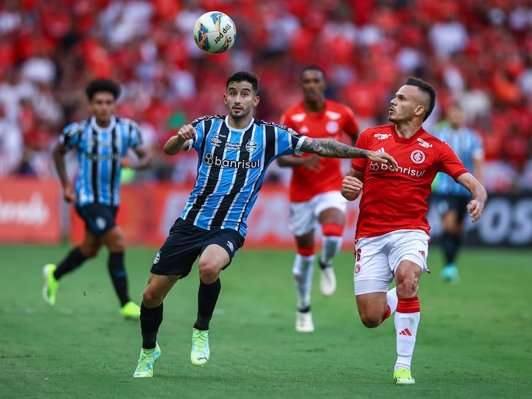 El paraguayo Mathías Villasanti (i), futbolista de Gremio, pelea por el balón en un partido del Estadual Gaúcho contra Internacional en el estadio Beira-Río, en Porto Alegre, Brasil.