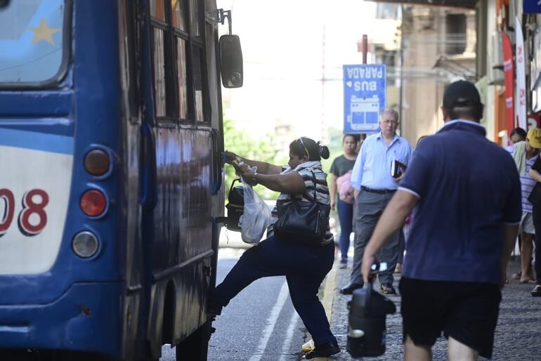 Una pasajera sube a un ómnibus en el centro de Asunción.