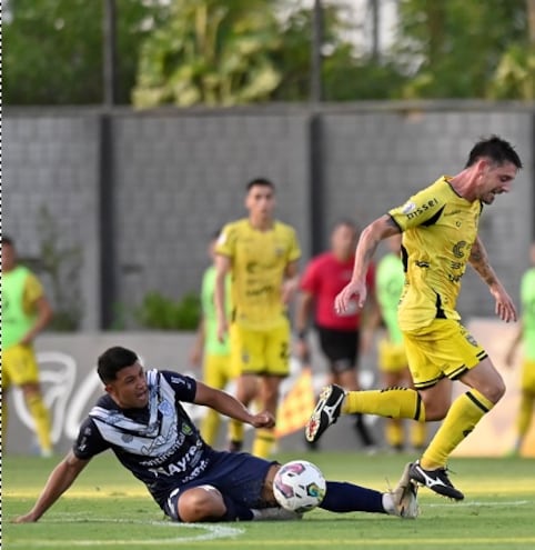 Alejandro Silva, autor del gol para Recoleta, intenta superar la marca de Jonathan Benítez de Ameliano, en el empate de anoche.