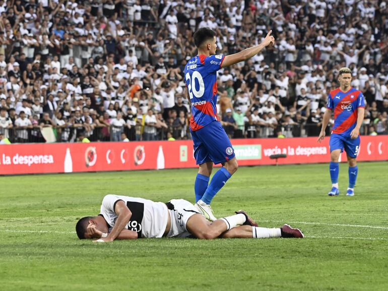 Brian Montenegro, futbolista de Olimpia, en el césped a causa de un golpe en la rodilla después de un choque con el arquero Miguel Martínez, jugador de Cerro Porteño, durante el superclásico en el estadio Manuel Ferreira, en Asunción.