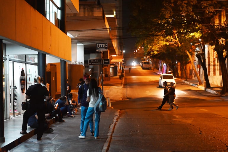 Usuarios del transporte público esperando buses en la calle Azara en horario nocturno.