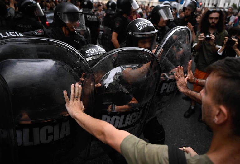 Manifestantes se enfrentan a la policía durante la manifestación realizada ayer en pleno centro de Buenos Aires, frente al Cine Gaumont.