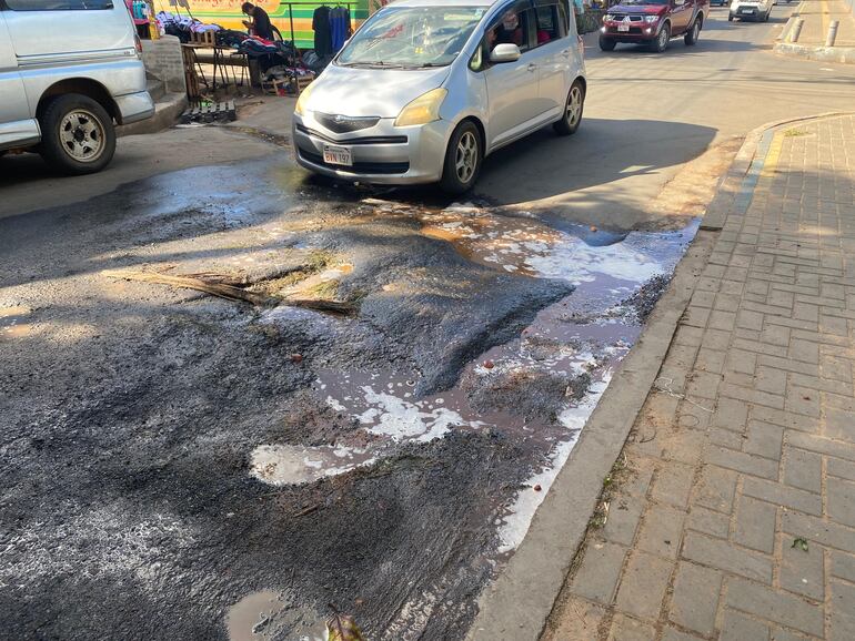 Bache en la Avda. Humaitá, lleno de agua y residuos, dificulta el paso de vehículos y peatones.