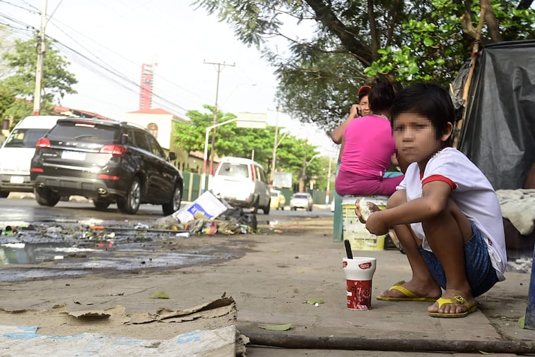 Un niño desayuna cocido negro y un pan, en plena avenida Artigas, en medio de la basura y el agua servida. La imagen fue una constante hasta el sábado, cuando el Gobierno "despejó" a los indígenas, a días del traspaso de mando.