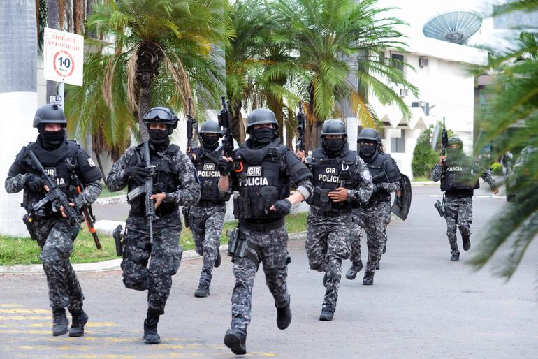 Policías ecuatorianos se movilizan en las inmediaciones de la sede de un canal de televisión tomado por atacantes armados el martes, en Guayaquil.