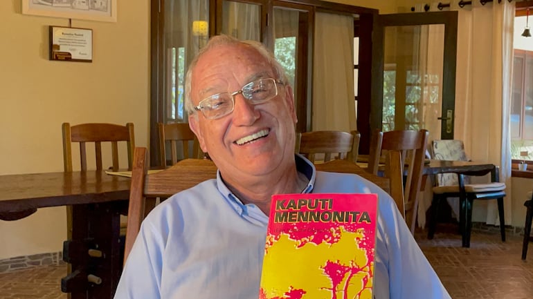 El historiador Kornelius Neufeld sosteniendo una edición del libro "Kaputi mennonita" escrito por Peter P. Klassen que relata los primeros años de asentamiento de los pioneros que colonizaron el Chaco hace casi 100 años.